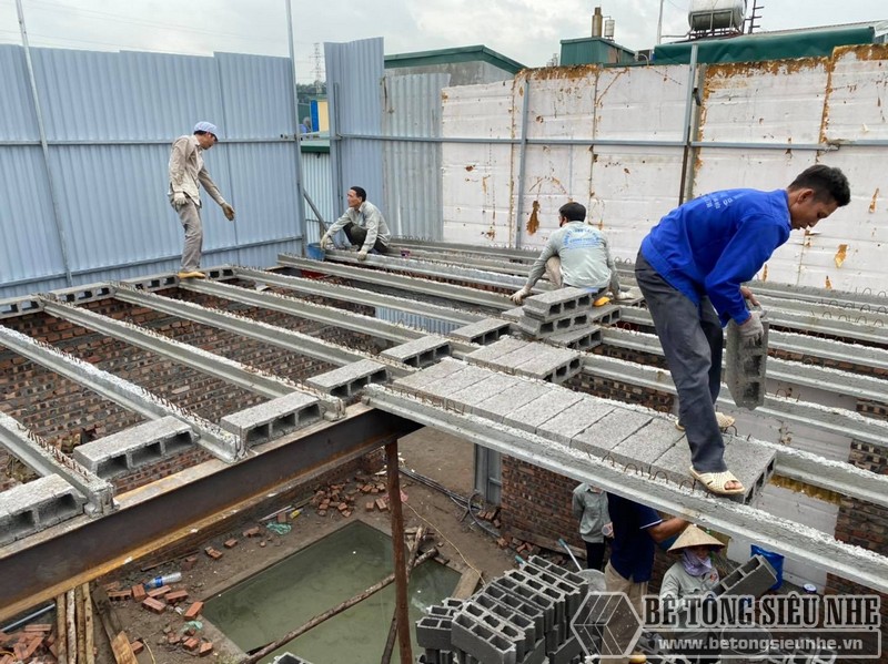 Hình ảnh công nhân đang lắp từng viên gạch Block nhẹ vào hệ dầm ứng lực tại nhà anh Trung, Tây Hồ